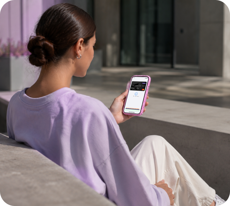 Woman sitting on a bench paying with her phone