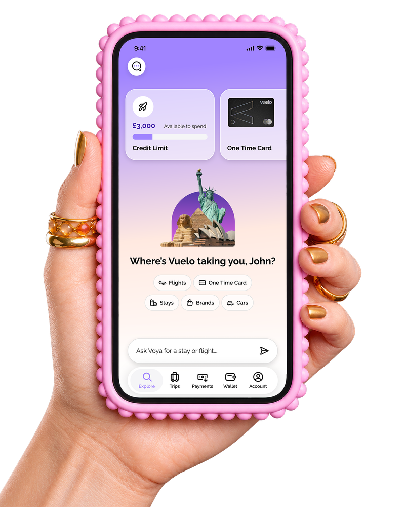 Hand holding a pink-cased phone showing the Vuelo app home screen